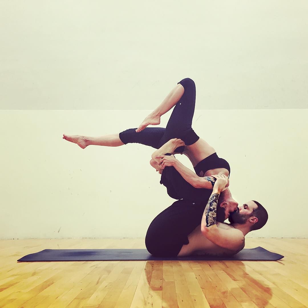 Young athletic couple practicing acroyoga. Balancing in pair. Fit active pair  yoga time. Sporty handsome man supporting and holding slim beautiful  brunette woman. Training time. Asana Stock Photo | Adobe Stock